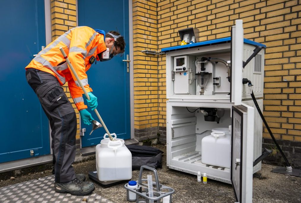Man in veiligheidskleren die monsters neemt op rwzi.